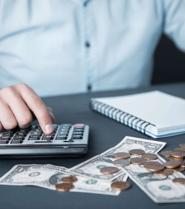 man hand money with calculator and notepad on desk